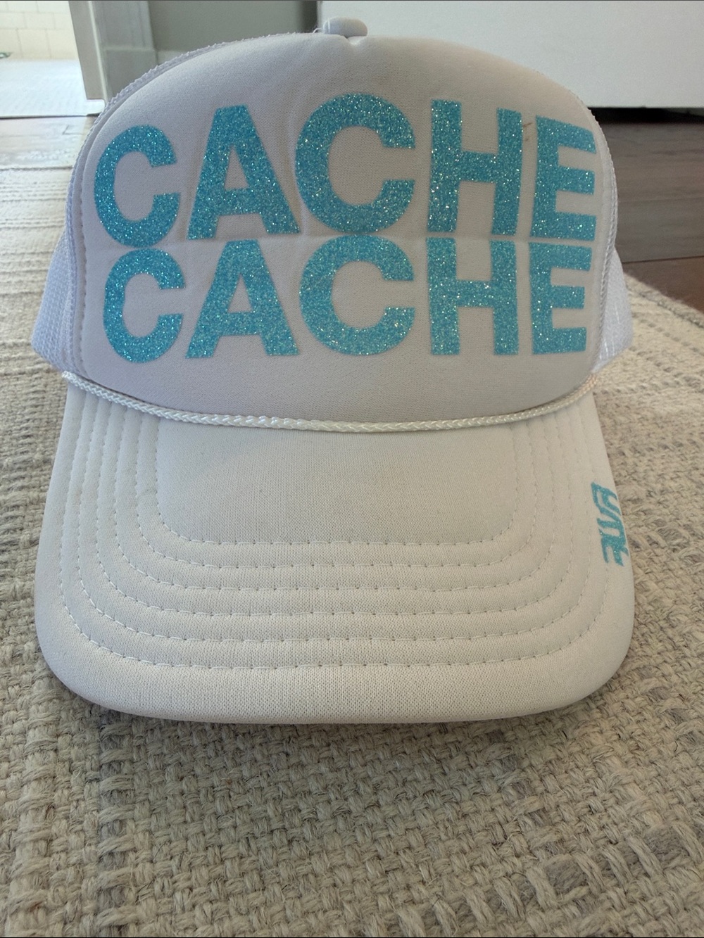 Aspen CACHE CACHE White Trucker Hat with Sparkling Teal lettering. Purchased in